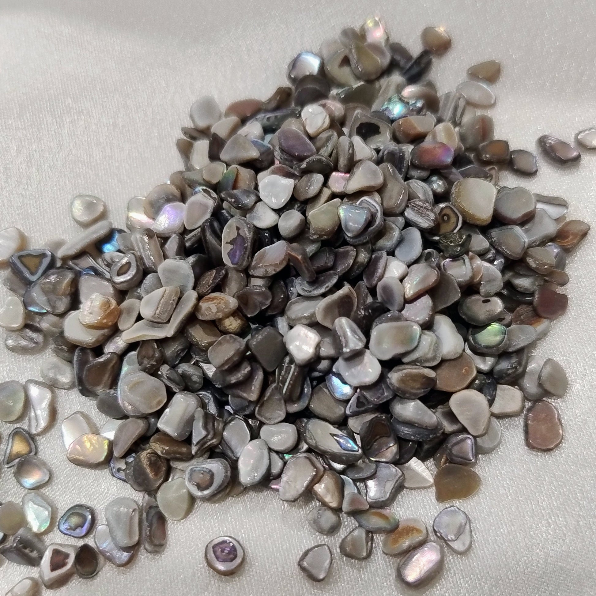 Small pebbles with metallic sheen on a light gray background