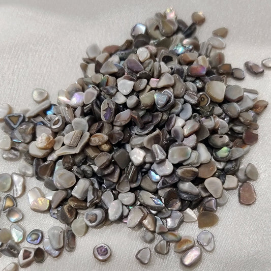 Small pebbles with metallic sheen on a light gray background